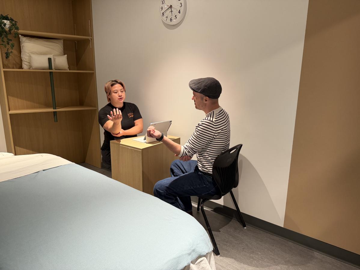 Second-year RMT student, Beverly Cheung, speaking with a client about his massage therapy needs.