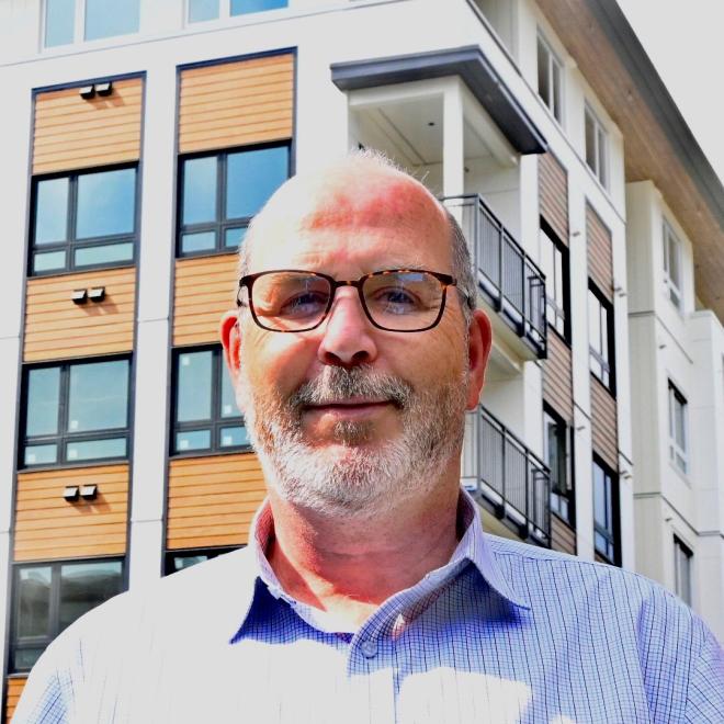 Real Estate instructor Stefan Baune in front of recently constructed condos.