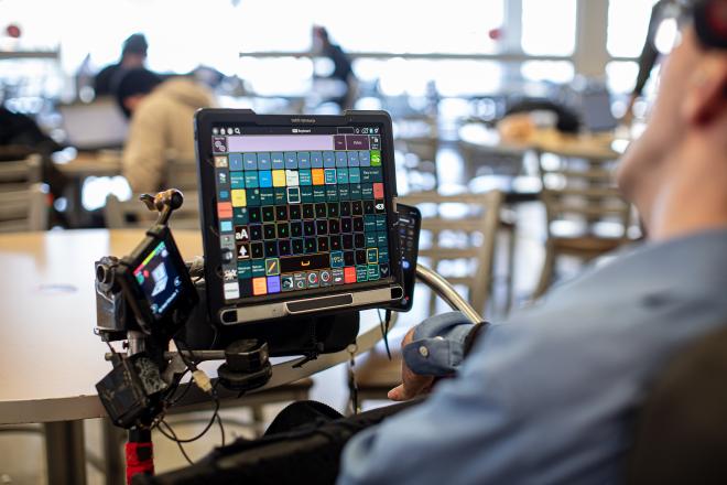 Ben Fullerton using his speech device while seated in his power wheelchair.