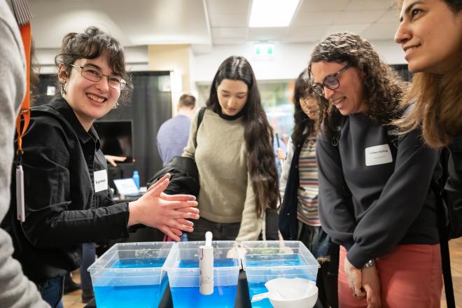 Student researcher, Karmen Legge, interacting with visitors to her booth at Applied Research Day.