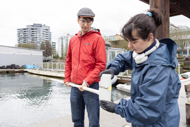 Instructor Kevin Rey working with student Karmen Legge sampling water at False Creek.
