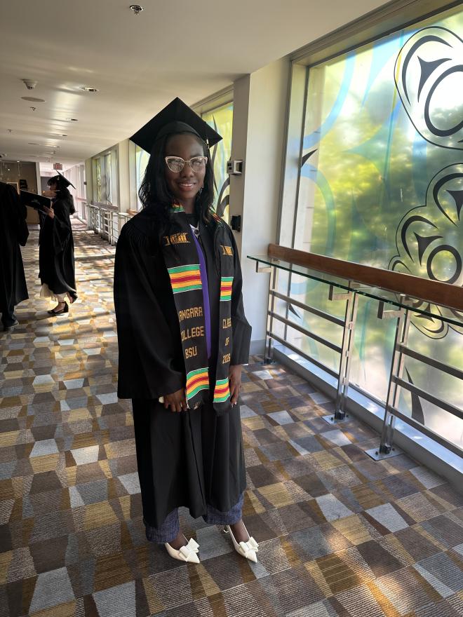Graduate, Grace Kumi, proudly wearing her convocation regalia and Kente stole.