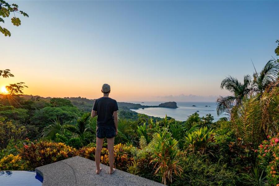 A student looks out at the lush view and nearby ocean in Costa Rica.