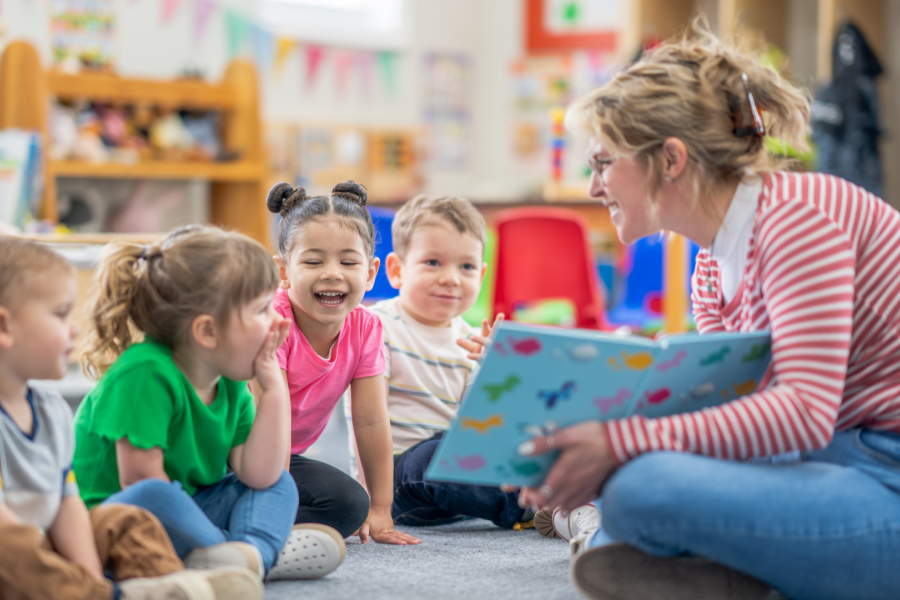 Early childhood educator with four students.