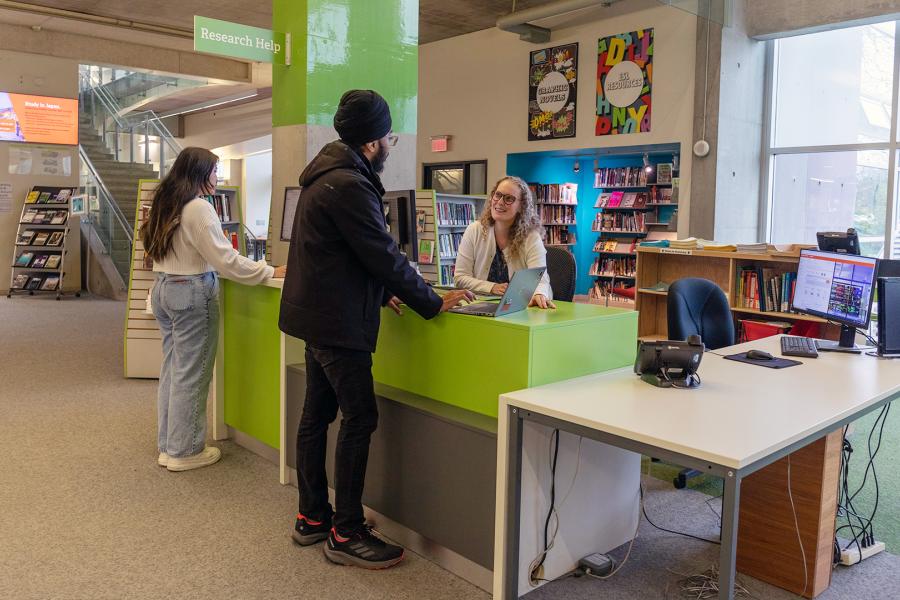 A student is receiving assistance at the library with their research.