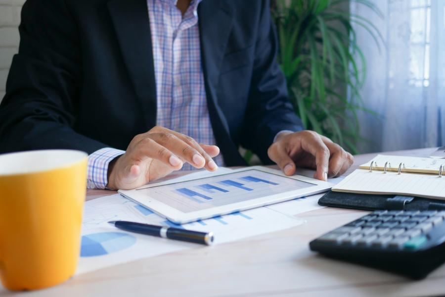 stock image of man looking at a graph on an ipad