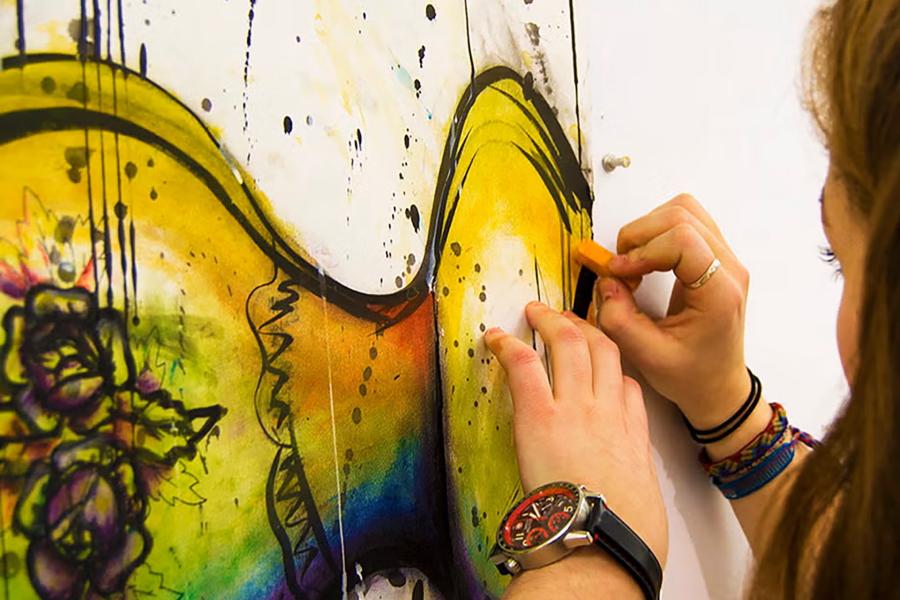 Student drawing a colourful picture.