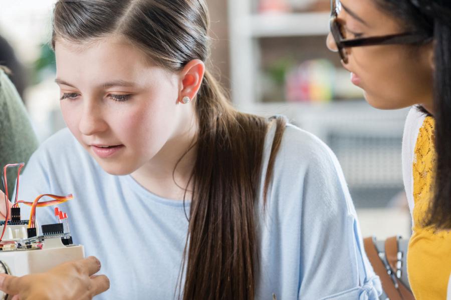 A teen engages in hands-on learning during her AI class.