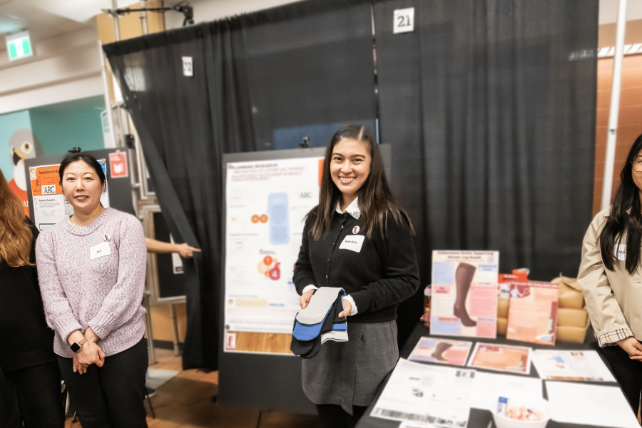 Nursing students smiling at their booth presenting their project at Applied Research Day 2026.