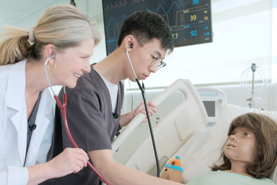 Nursing student, Tim Pham, and instructor, Mary Peters, working with a high-fidelity mannequin in a simulated care scenario.