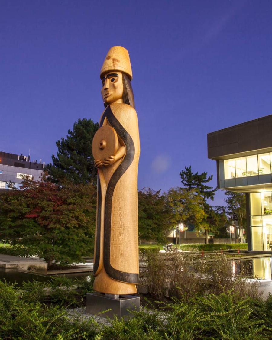 The Musqueam House Post near the Langara Pond at night.