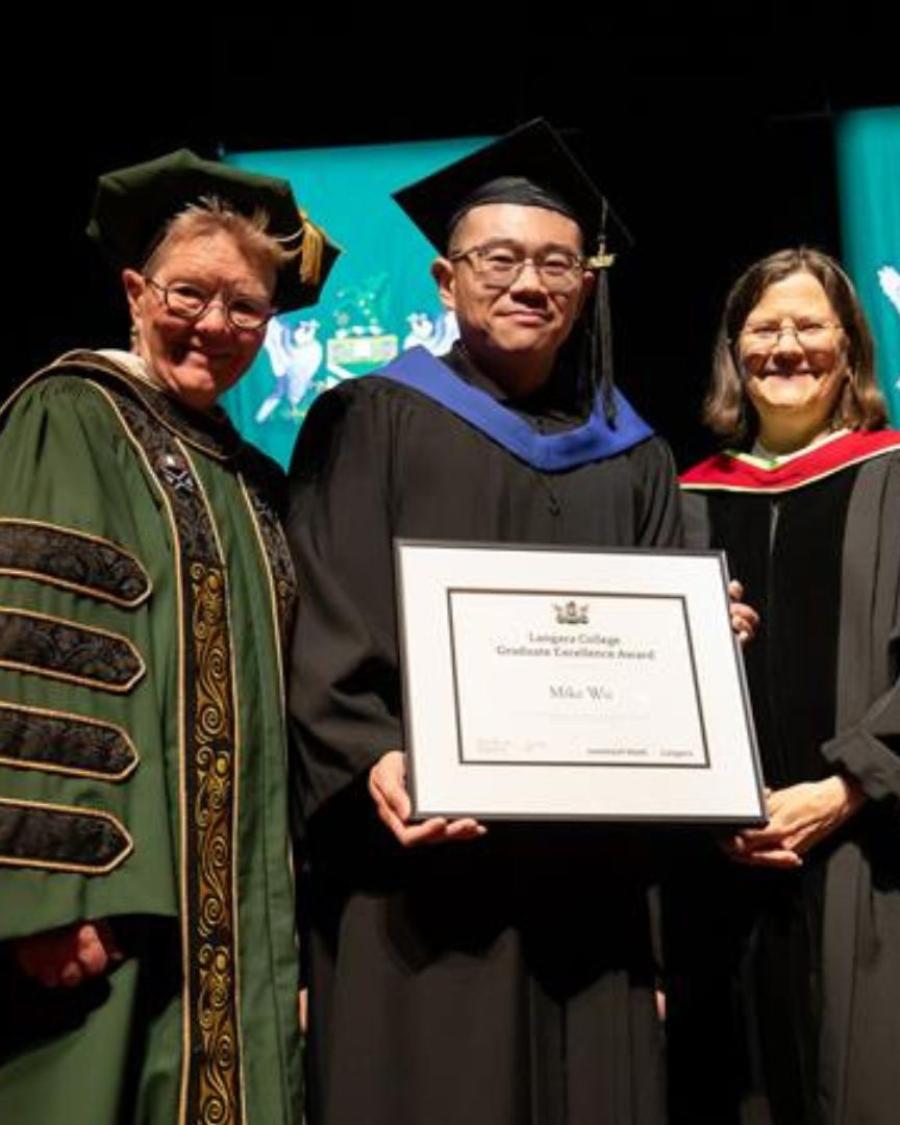 Dr. Paula Burns presents Bioinformatics graduate Mike Wu with his degree. 